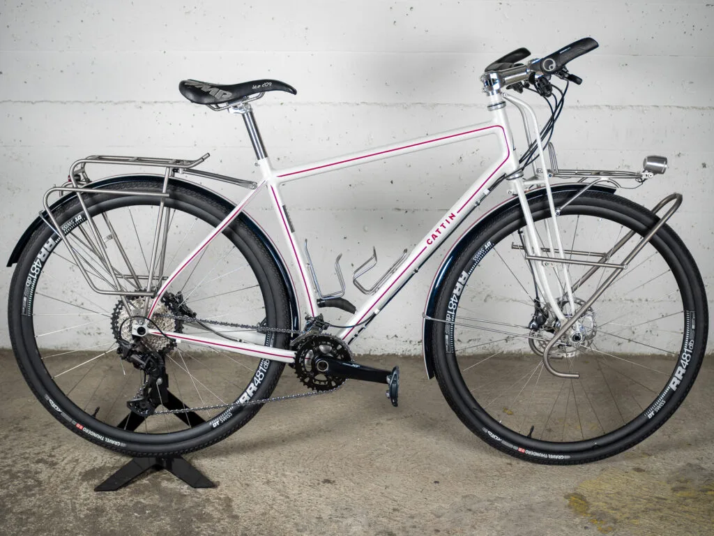 Vélo de voyage blanc et rouge à freins à disuqe et fourche truss
